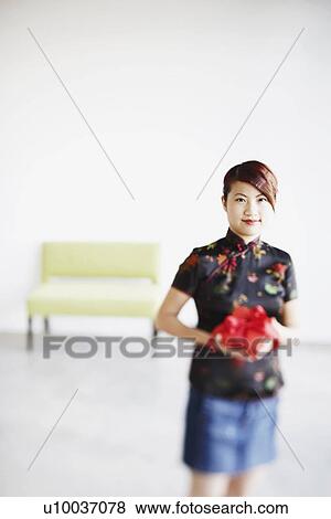 Portrait of a young woman holding a gift in her hands View Large Photo Image Stock Photo - Portrait of a young woman holding a gift in her hands. Fotosearch
