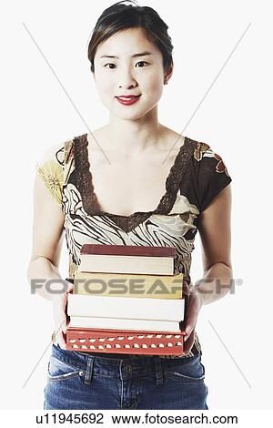 Portrait of a young woman holding books View Large Photo Image Stock Image - Portrait of a young woman holding books. Fotosearch
