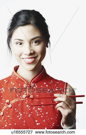 Portrait of a young woman holding chopsticks View Large Photo Image Stock Photo - Portrait of a young woman holding chopsticks. Fotosearch