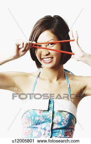 Portrait of a young woman looking through chopsticks View Large Photo Image Stock Image - Portrait of a young woman looking through chopsticks. Fotosearch