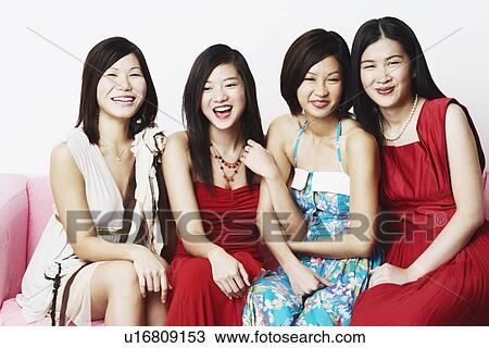 Stock Image - Portrait of four young women sitting together. Fotosearch