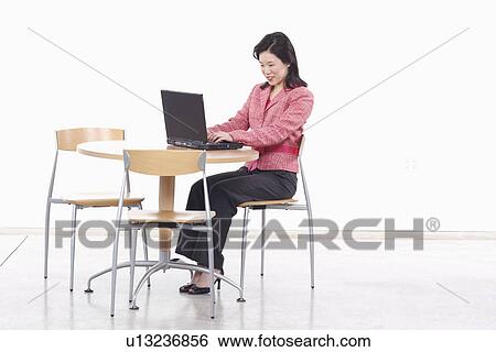 Side profile of a businesswoman using a laptop View Large Photo Image Stock Photograph - Side profile of a businesswoman using a laptop. Fotosearch
