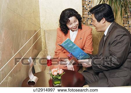 Stock Photo - Businessman and a businesswoman sitting in a restaurant. Fotosearch