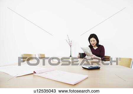 Businesswoman reading a newspaper View Large Photo Image Stock Image - Businesswoman reading a newspaper. Fotosearch