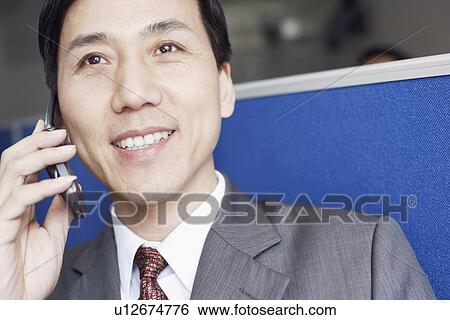 Close-up of a businessman talking on a mobile phone View Large Photo Image Stock Photograph - Close-up of a businessman talking on a mobile phone. Fotosearch