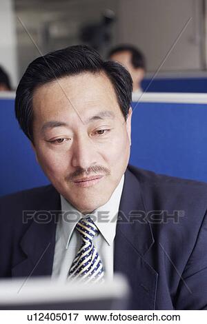 Stock Photo - Close-up of a businessman using a computer. Fotosearch