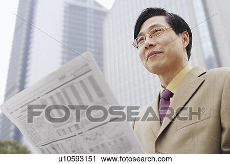 Stock Image - Close-up of a businessman with a newspaper. Fotosearch