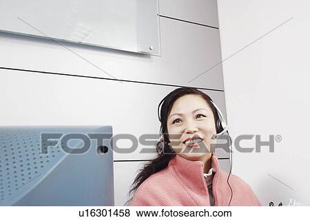 Stock Photo - Close-up of a customer service representative wearing a headset. Fotosearch