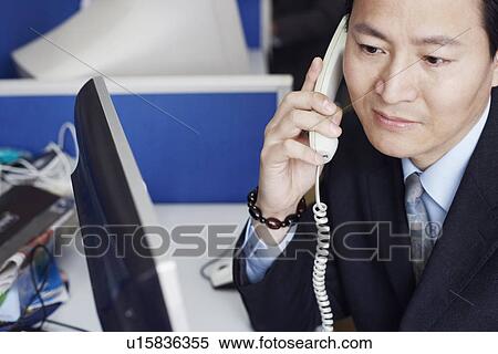Stock Photography - High angle view of a businessman talking on the telephone. Fotosearch
