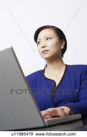Low angle view of a businesswoman using a laptop View Large Photo Image Stock Photo - Low angle view of a businesswoman using a laptop. Fotosearch