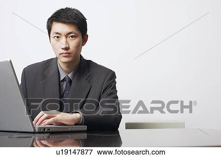 Stock Photo - Portrait of a businessman using a laptop. Fotosearch