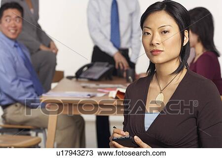 Stock Image - Portrait of a businesswoman holding a personal data assistant. Fotosearch