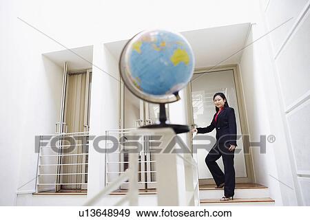 Stock Photo - Portrait of a businesswoman standing on a staircase and smiling. Fotosearch