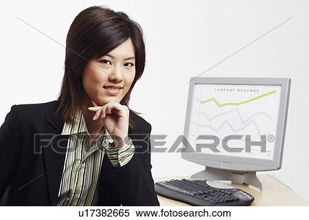 Stock Photography - Portrait of a businesswoman with a progress report in the background. Fotosearch