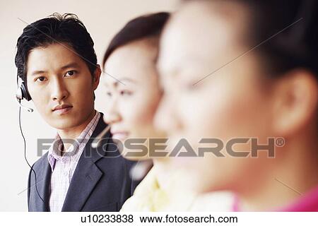 Stock Photo - Portrait of a male customer service representative with two colleagues. Fotosearch