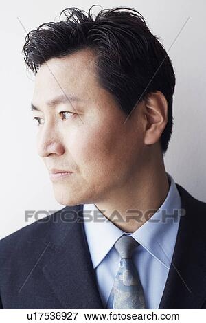 Stock Photo - Close-up of a businessman looking sideways smiling. Fotosearch