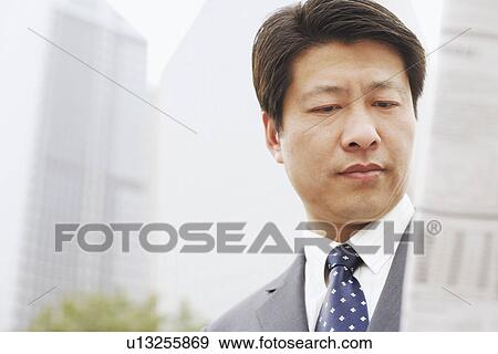 Stock Photo - Close-up of a businessman reading a newspaper. Fotosearch