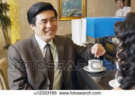 Stock Photography - Close-up of a mature man stirring a cup of coffee. Fotosearch