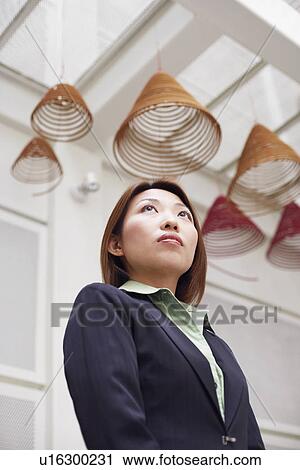 Low angle view of a businesswoman thinking View Large Photo Image Stock Image - Low angle view of a businesswoman thinking. Fotosearch
