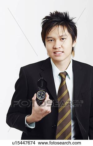 Portrait of a businessman holding a compass View Large Photo Image Picture - Portrait of a businessman holding a compass. Fotosearch