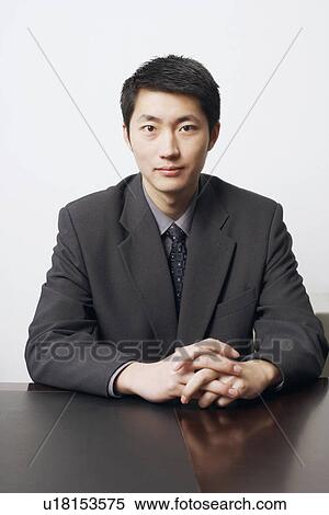 Portrait of a businessman sitting with his hands clasped View Large Photo Image Stock Photography - Portrait of a businessman sitting with his hands clasped. Fotosearch