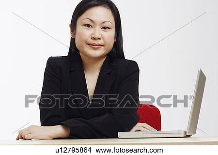 Portrait of a businesswoman sitting with a laptop View Large Photo Image Picture - Portrait of a businesswoman sitting with a laptop. Fotosearch