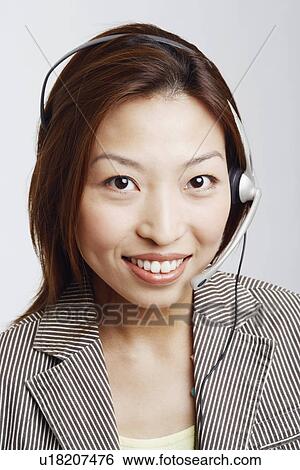 Stock Photograph - Portrait of a businesswoman wearing a headset and smiling. Fotosearch