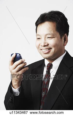 Close-up of a businessman looking at a mobile phone View Large Photo Image Stock Photo - Close-up of a businessman looking at a mobile phone. Fotosearch