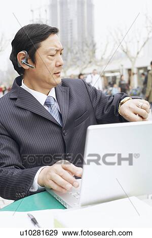 Close-up of a businessman looking at his wrist watch View Large Photo Image Stock Photo - Close-up of a businessman looking at his wrist watch. Fotosearch