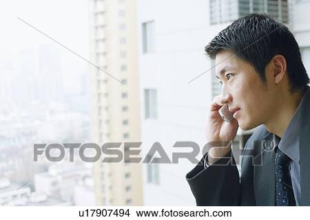 Picture - Close-up of a businessman using a mobile phone. Fotosearch