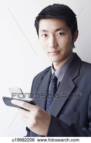Portrait of a businessman holding a mobile phone View Large Photo Image Stock Photo - Portrait of a businessman holding a mobile phone. Fotosearch