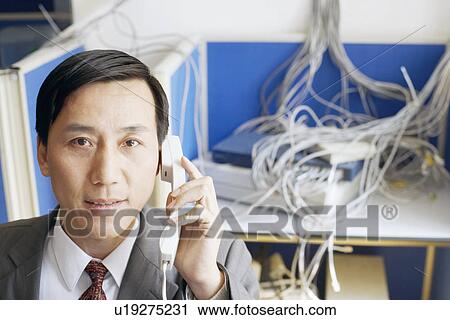 Portrait of a businessman using a telephone in a server room View Large Photo Image Stock Image - Portrait of a businessman using a telephone in a server room. Fotosearch