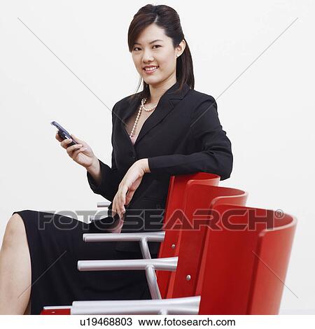 Portrait of a businesswoman holding a mobile phone and smiling View Large Photo Image Stock Image - Portrait of a businesswoman holding a mobile phone and smiling. Fotosearch