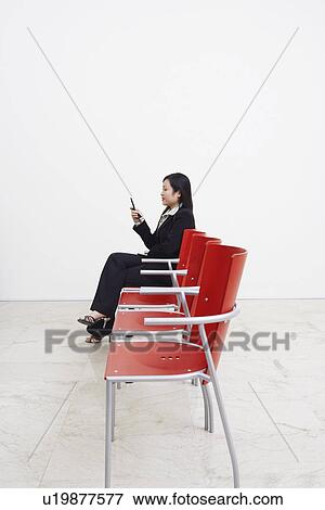 Side profile of a businesswoman looking at a mobile phone View Large Photo Image Stock Photo - Side profile of a businesswoman looking at a mobile phone. Fotosearch