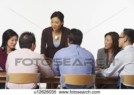 Stock Photography - Business executives discussing in a conference room. Fotosearch