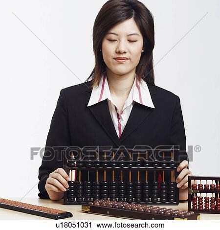 Stock Image - Businesswoman holding an abacus. Fotosearch
