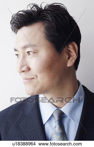 Picture - Close-up of a businessman looking sideways smiling. Fotosearch