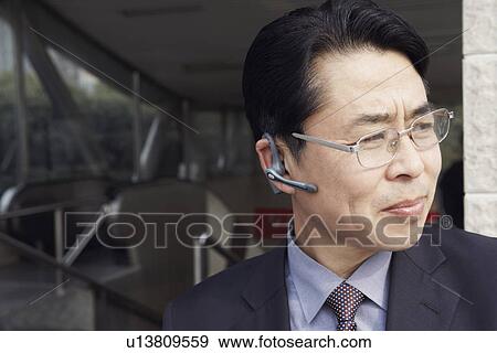 Stock Photo - Close-up of a businessman looking sideways smiling. Fotosearch