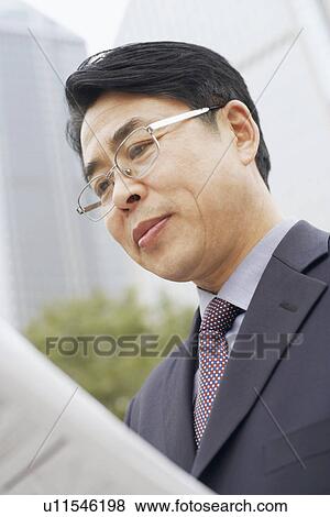 Close-up of a businessman reading a newspaper View Large Photo Image Stock Photo - Close-up of a businessman reading a newspaper. Fotosearch