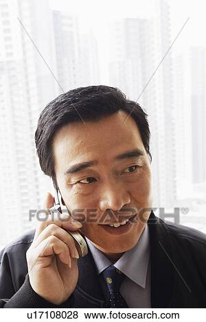 Stock Photo - Close-up of a businessman talking on a mobile phone. Fotosearch