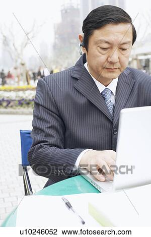 Close-up of a businessman using a laptop View Large Photo Image Stock Image - Close-up of a businessman using a laptop. Fotosearch