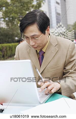 Close-up of a businessman using a laptop View Large Photo Image Stock Photo - Close-up of a businessman using a laptop. Fotosearch