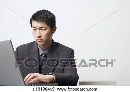 Stock Photo - Close-up of a businessman using a laptop. Fotosearch
