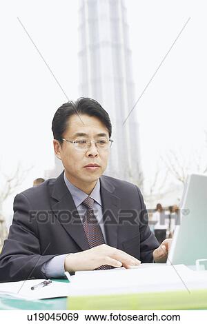 Close-up of a businessman using a laptop View Large Photo Image Stock Photo - Close-up of a businessman using a laptop. Fotosearch
