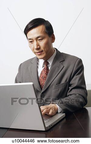 Stock Photograph - Close-up of a businessman using a laptop. Fotosearch