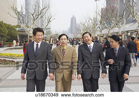 Four businessmen walking together View Large Photo Image Stock Photo - Four businessmen walking together. Fotosearch