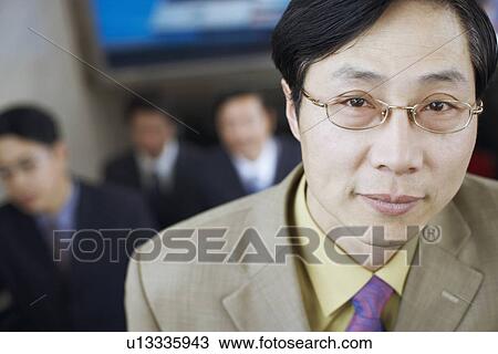 Stock Image - Portrait of a businessman on an escalator. Fotosearch