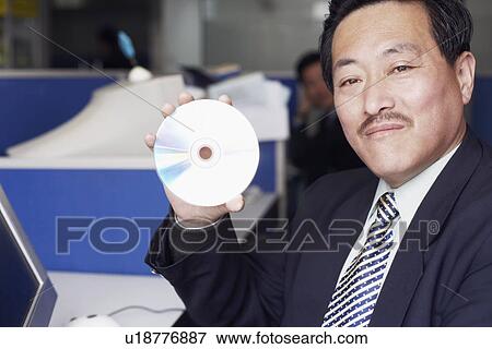Portrait of a businessman showing a CD View Large Photo Image Stock Photo - Portrait of a businessman showing a CD. Fotosearch