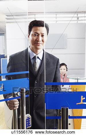 Stock Photograph - Portrait of a businessman standing in an office with a mature woman wearing a headset. Fotosearch