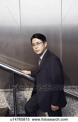 Stock Photography - Portrait of a businessman walking up a staircase. Fotosearch